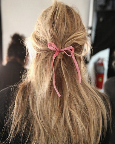 pink hair ribbon on girl with tousled blonde hair