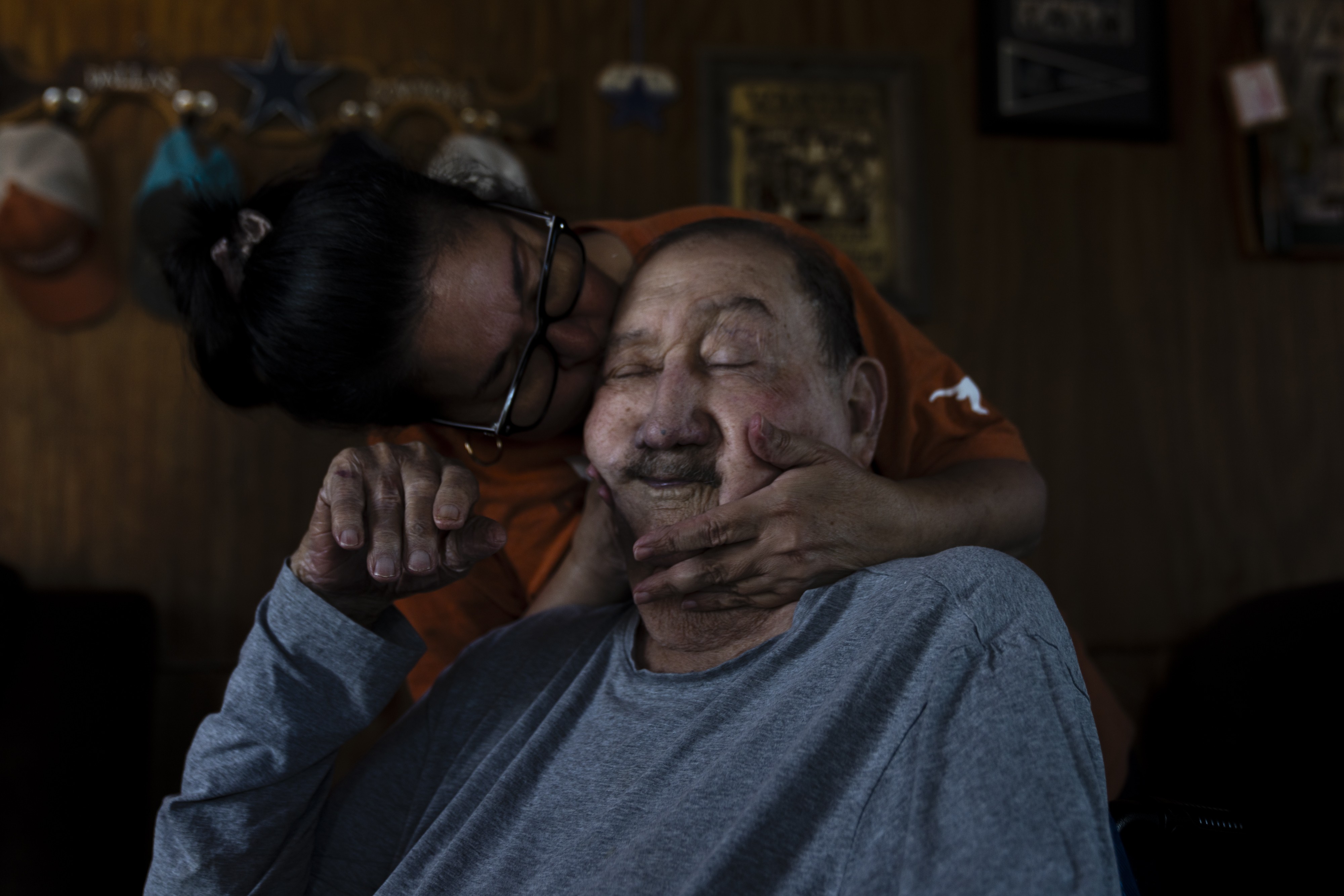 A photograph of Carmen Saenz-Lopez kissing her father, Francisco 'Pancho' Saenz, while visiting to help with caregiving duties in November 2023.