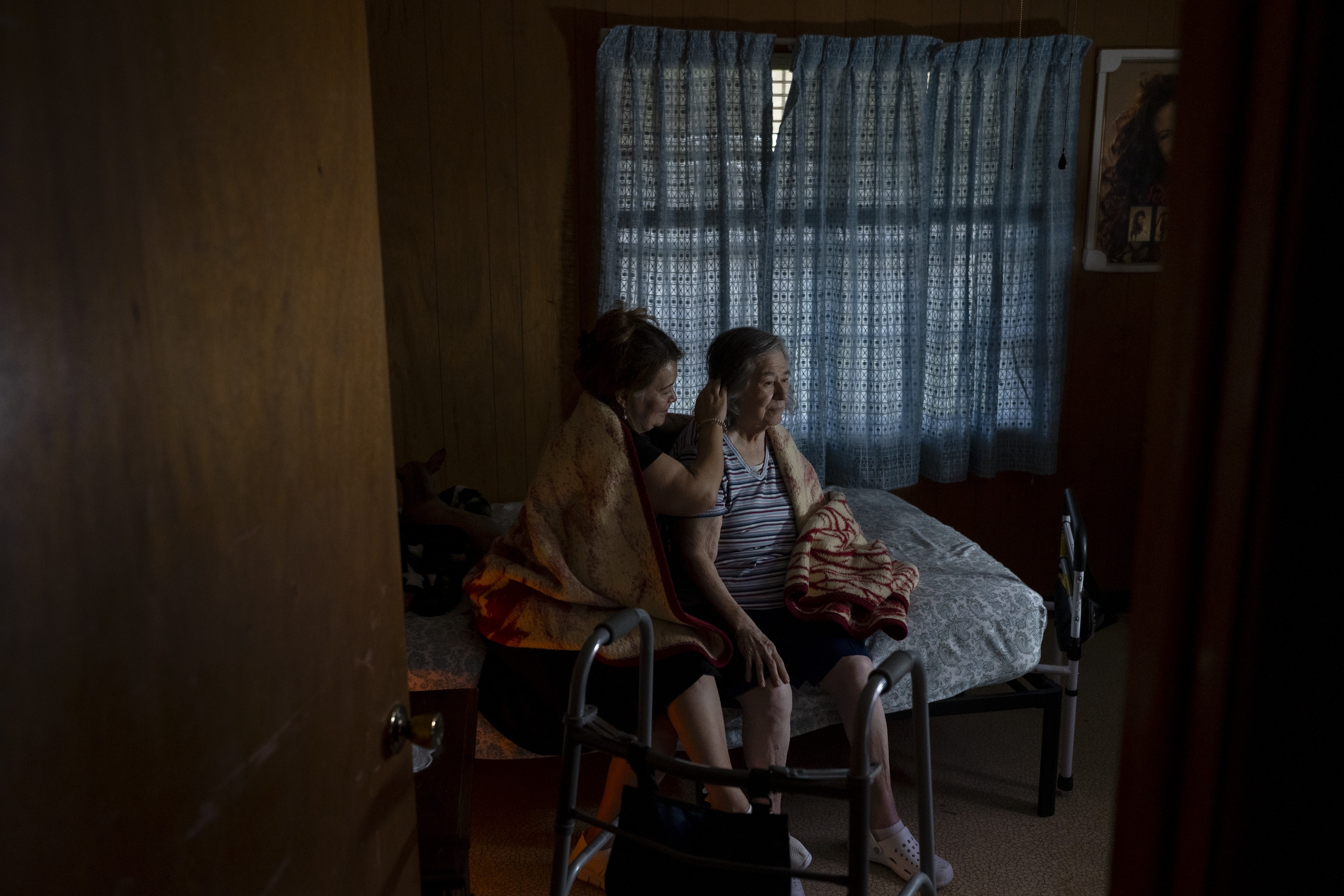 A photograph of Monica Saenz Silva sitting with her mother, Ramona, and tucking her hair behind her ear in December 2023