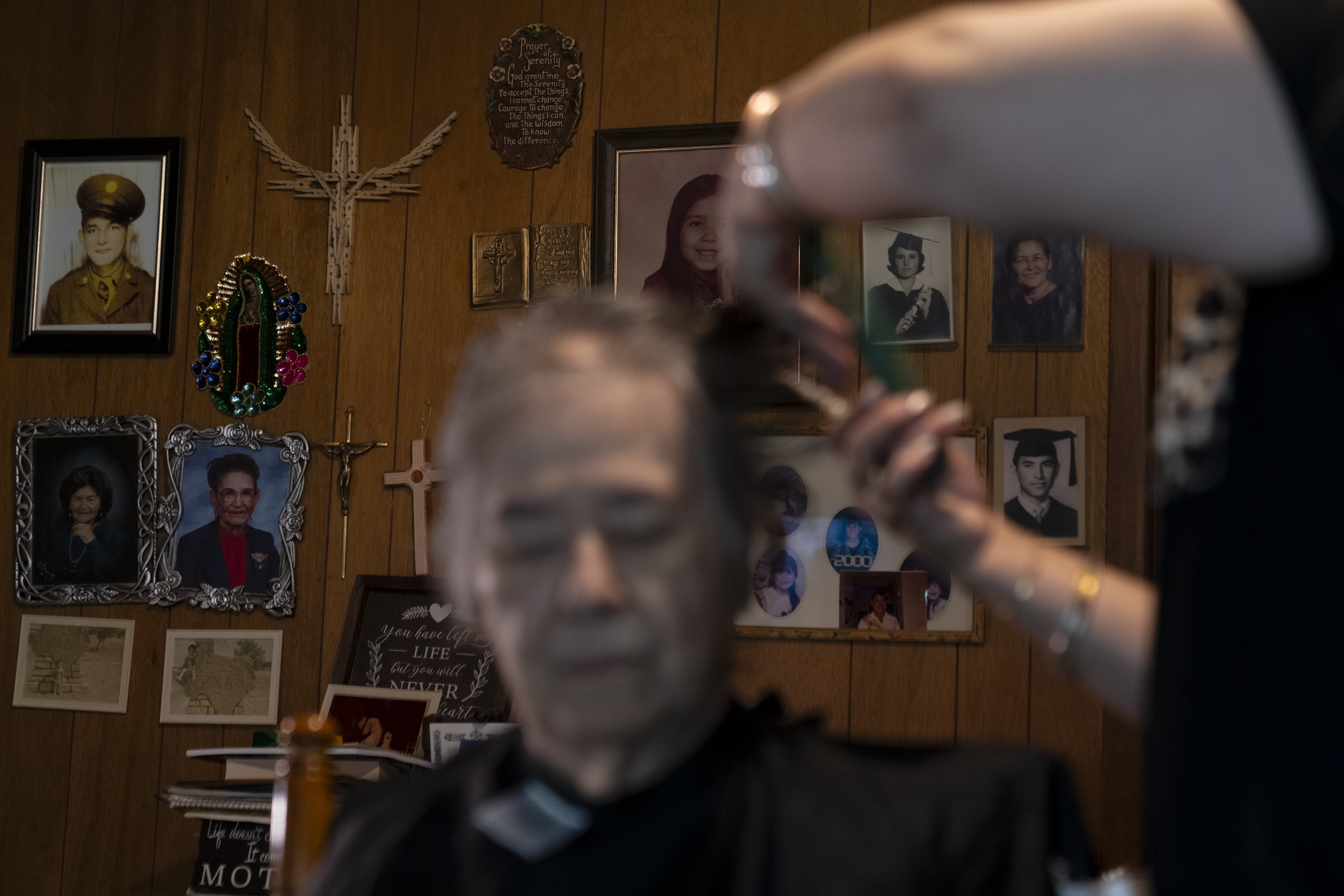 A photograph of Monica cutting her mother Ramona’s hair in Ramona’s living room in March 2023